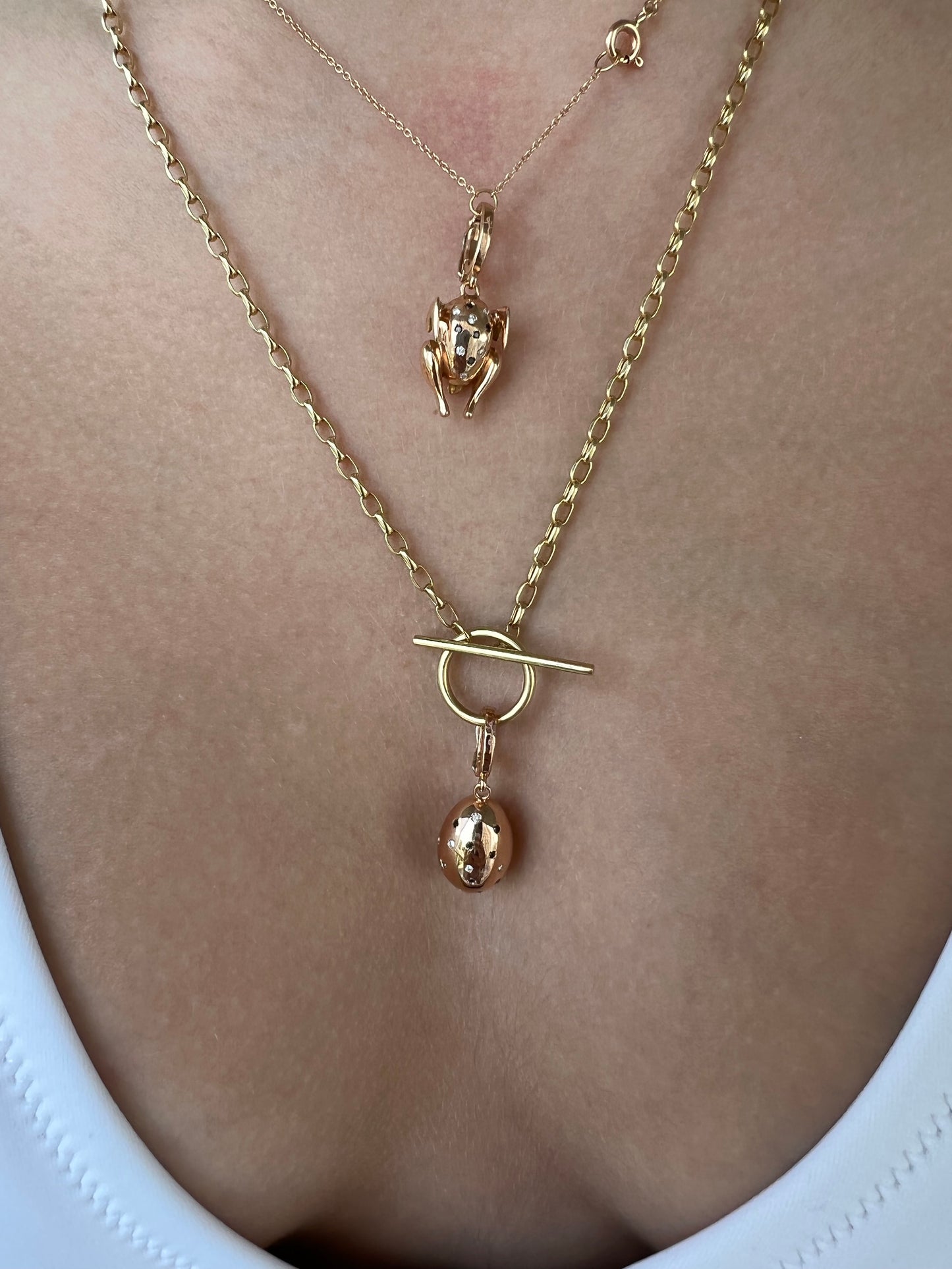 Lucky beginning egg charm with black and white diamonds in pink solid gold