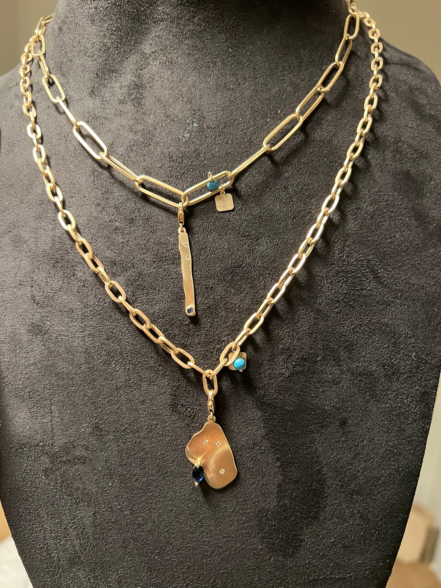 Semi matte finish dash charm with a blue sapphire and diamonds in yellow gold